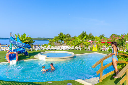 Outdoor swimming pool with water slide and paddling pool at CAPFUN Paillotte campsite in AZUR (40).