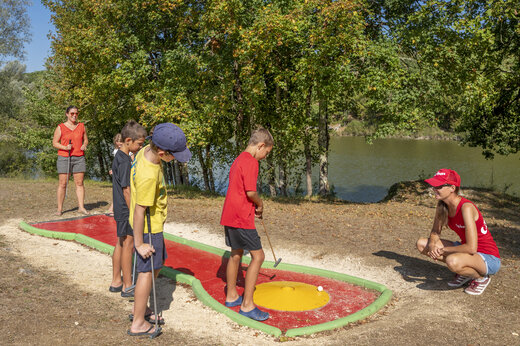 Children playing mini-golf near the lake at CAPFUN Ullule campsite in Tournon d'Agenais (47).
