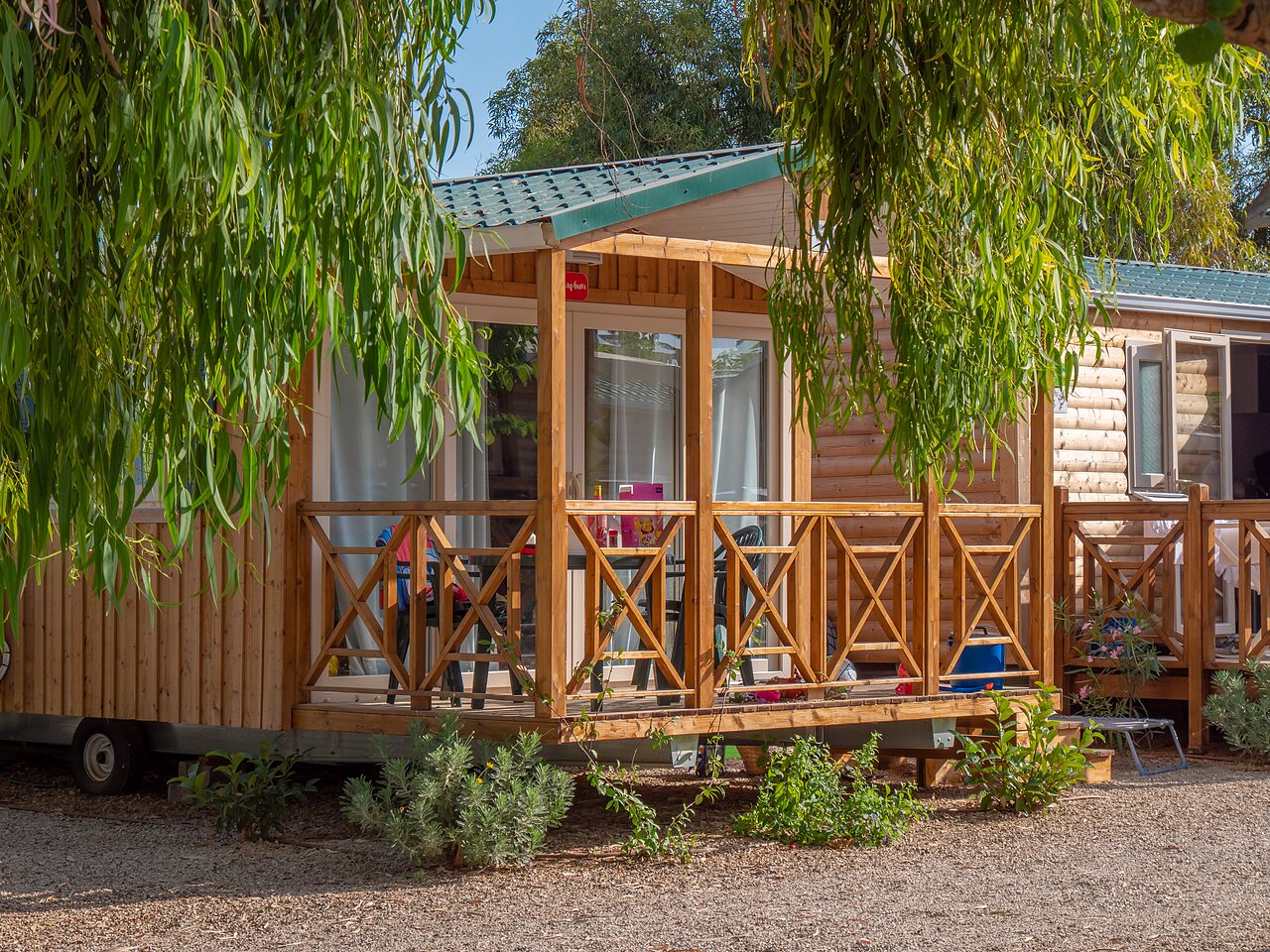 Wooden Mobil-home with shaded terrace and furniture at CAPFUN Alba campsite in CREIXELL (43).