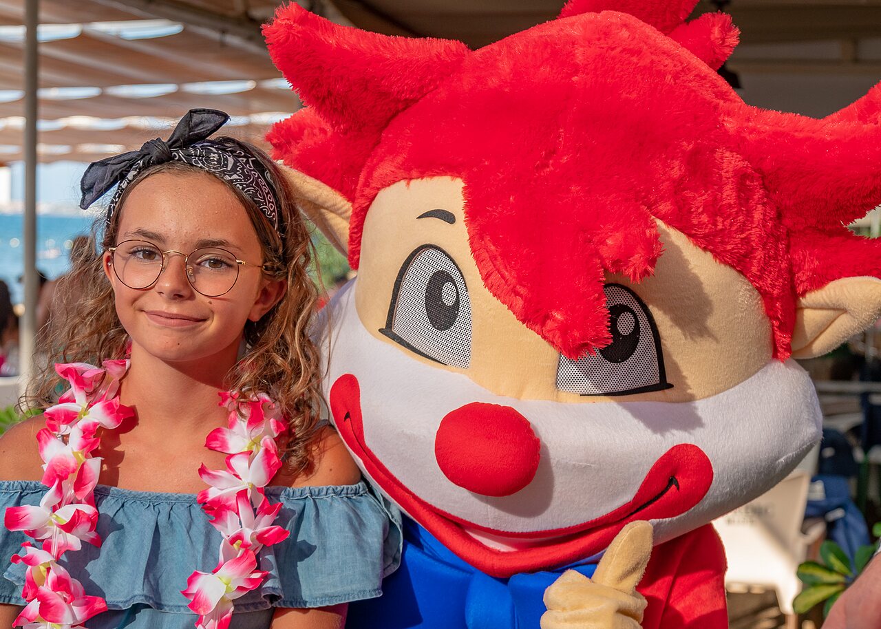 Smiling young girl with mascot at CAPFUN Alba campsite in CREIXELL (43).
