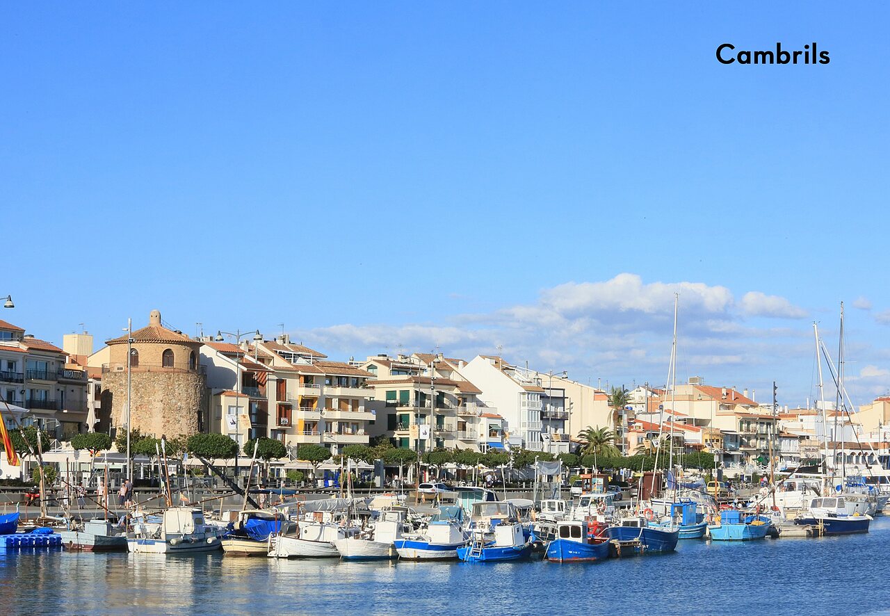 Cambrils harbor with fishing boats and coastal buildings, a place to visit.