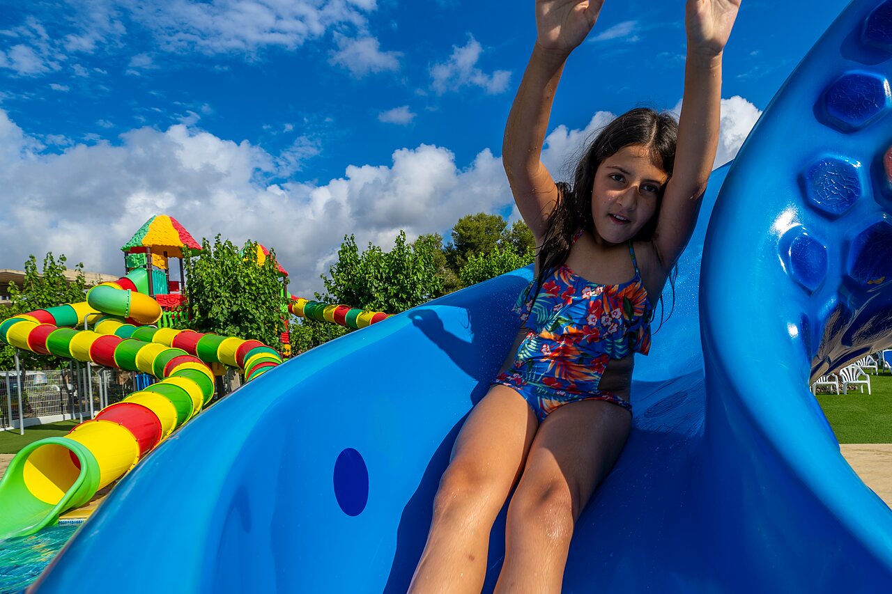 Blue water slide with smiling child at CAPFUN Alba campsite in CREIXELL (43).
