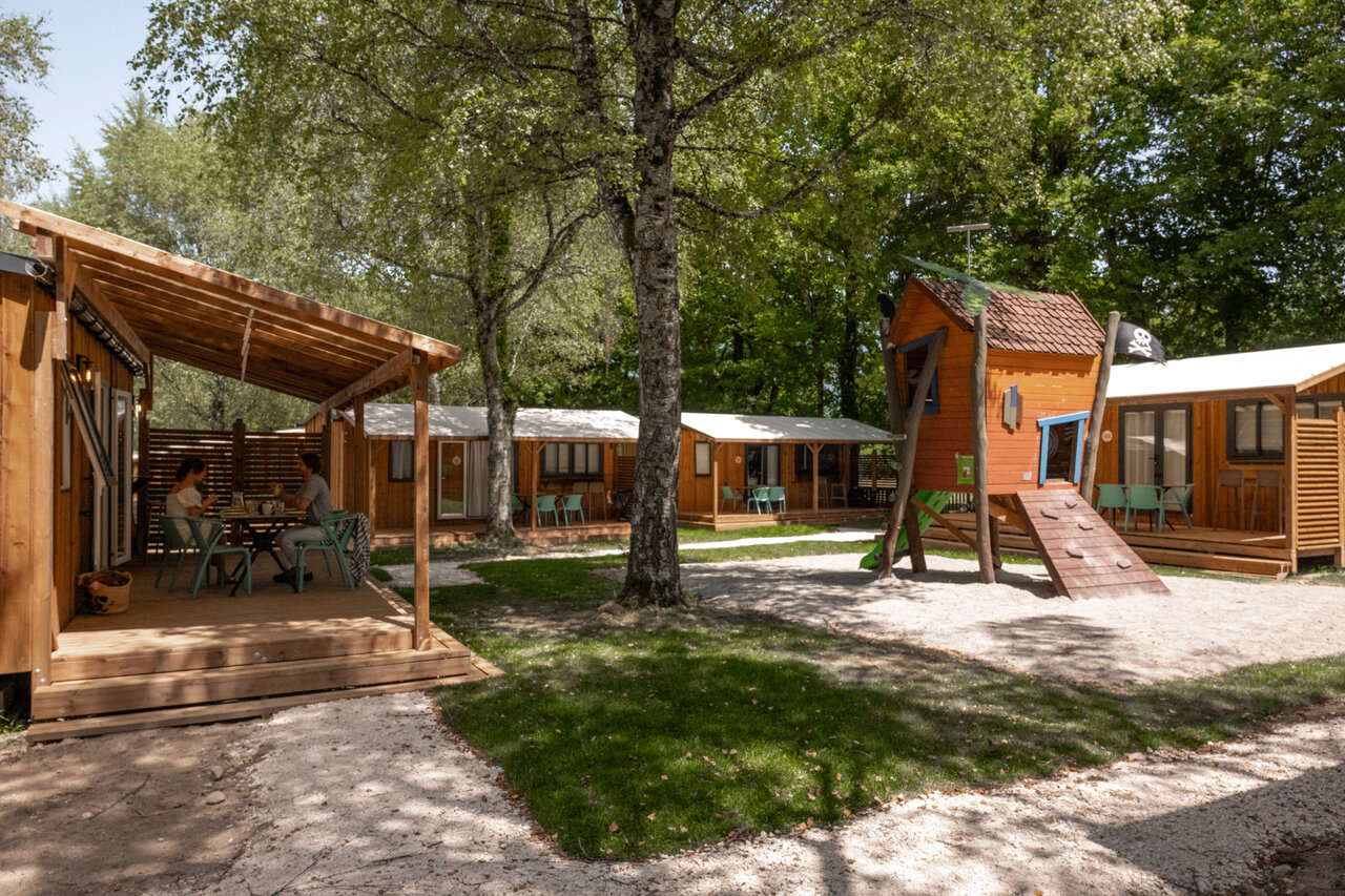 Wooden chalets with terrace and playground at CLICOCHIC Aloua campsite in Sevrier (74).