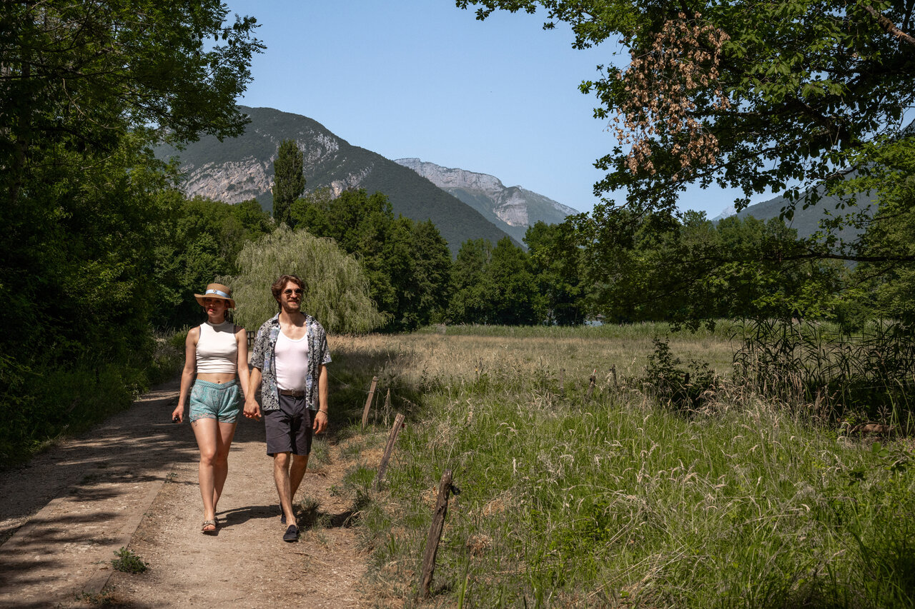 Couple walking in nature with mountains at camping CLICOCHIC Aloua in Sevrier (74).