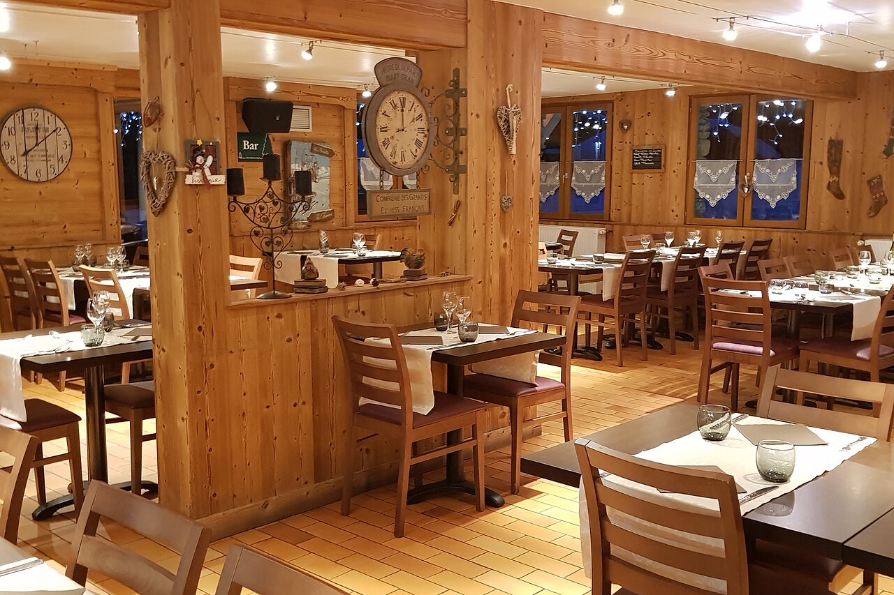 Warm restaurant interior with wooden tables and chairs at CLICOCHIC Alpes Lodges campsite in Pralognan la Vanoise (73).