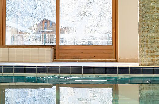 Indoor swimming pool, snowy view at CLICOCHIC Alpes Lodges campsite in Pralognan (73).
