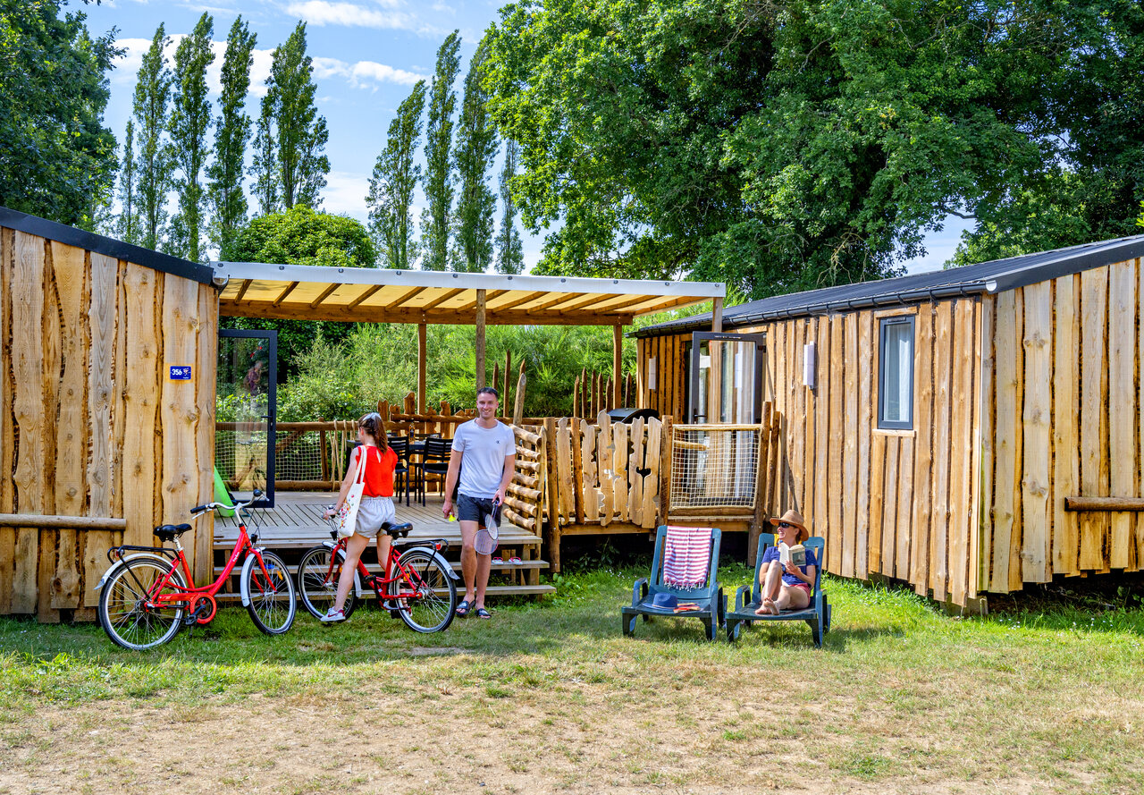 Wooden mobile homes, bicycles, and family at CAPFUN An Trest campsite in SARZEAU (56).