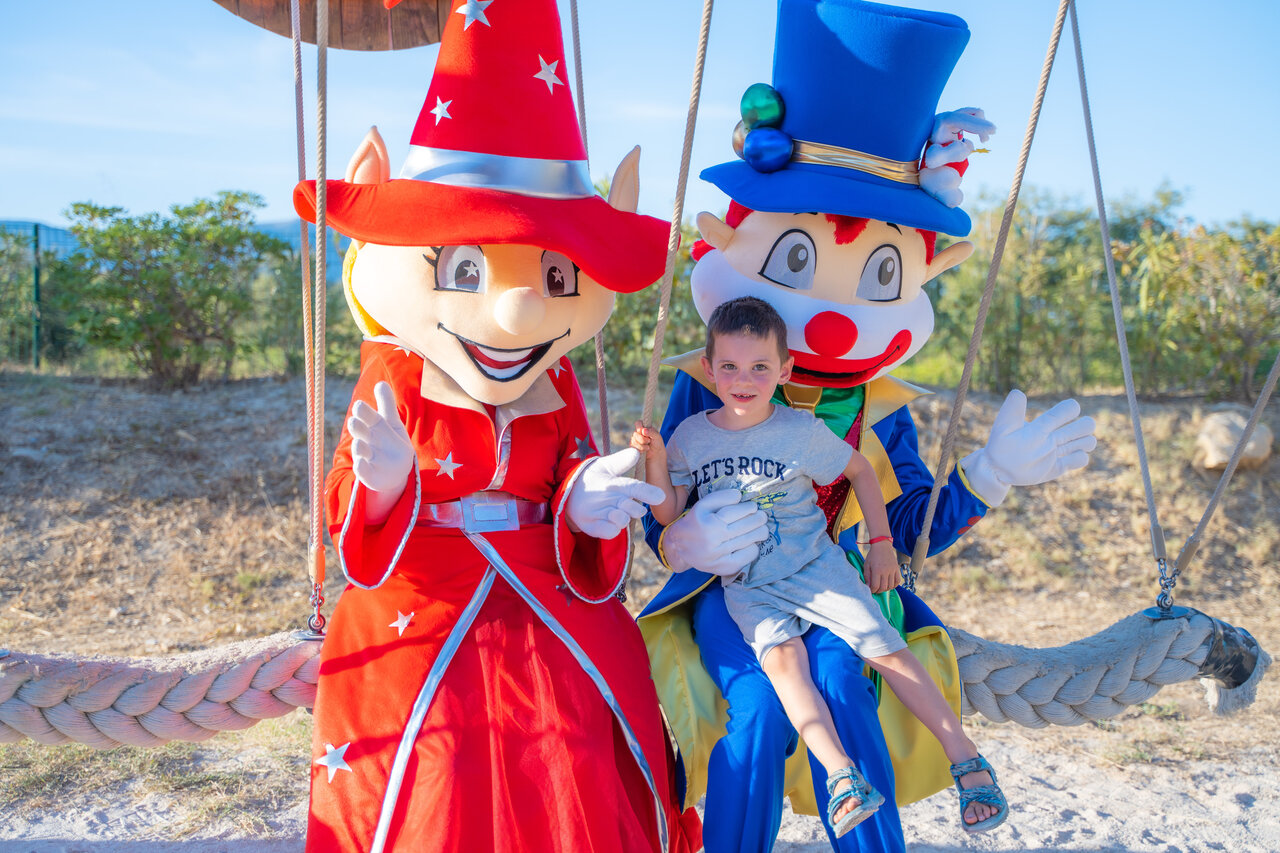 Smiling child with animation mascots at CAPFUN Arbois du Castellet campsite in LE CASTELLET (83).
