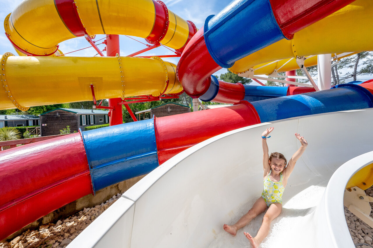 Water slides and smiling child at CAPFUN Arbois du Castellet campsite, LE CASTELLET (83).