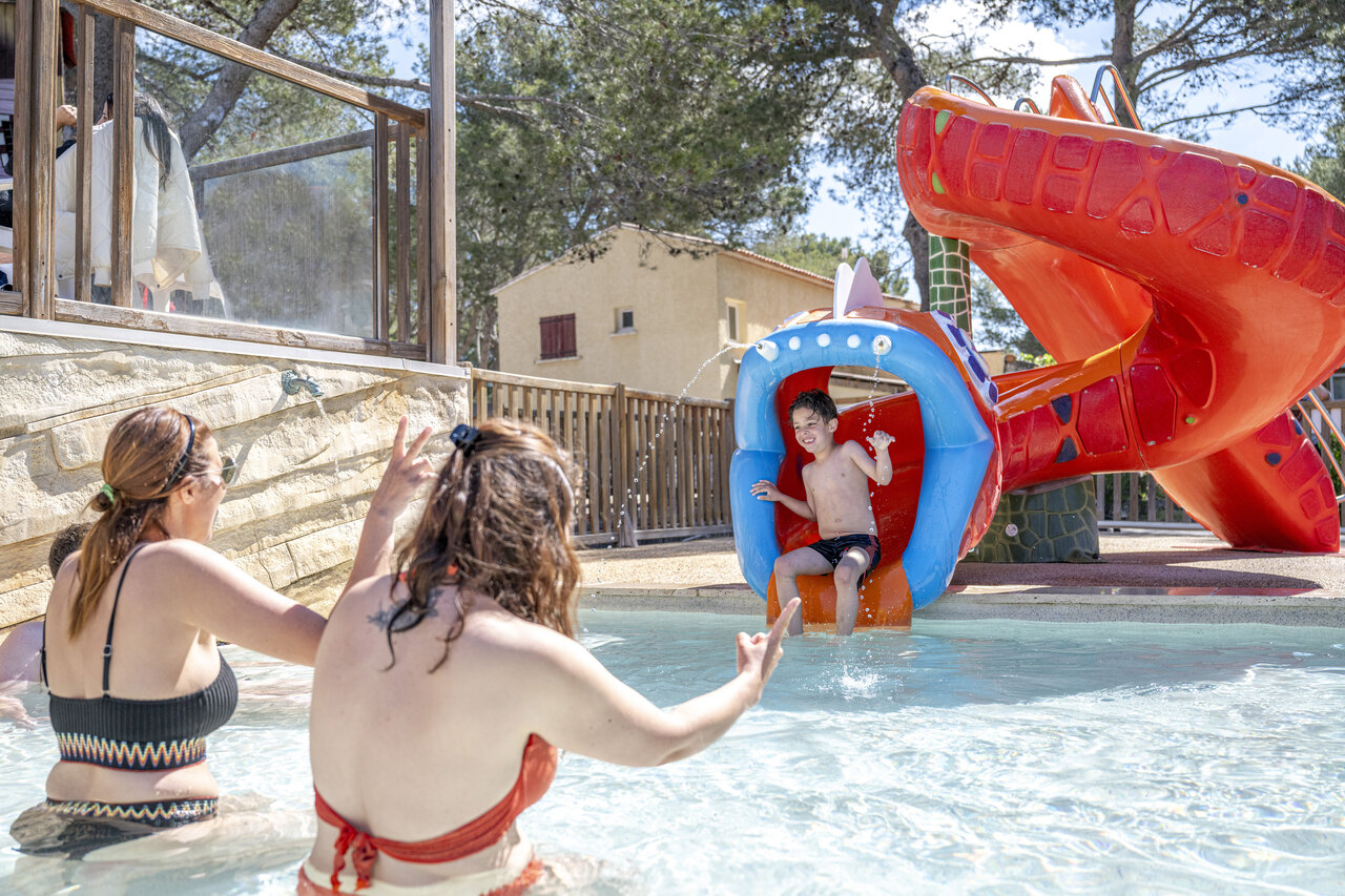 Child on water slide and pool, CAPFUN Arbois du Castellet campsite (83).