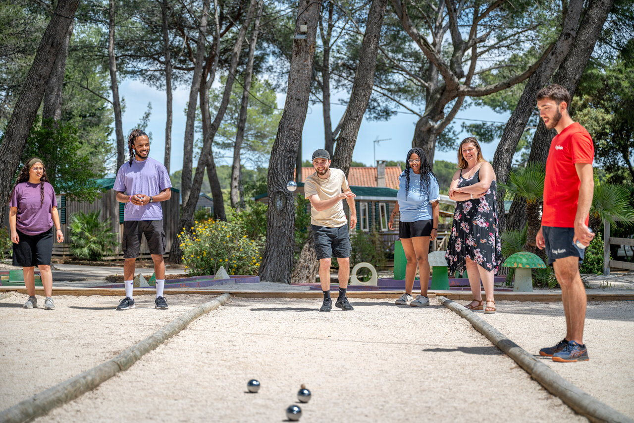 Friends playing p�tanque on the court at CAPFUN Arbois du Castellet campsite (83).