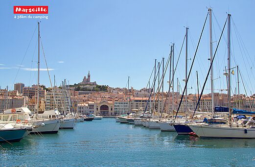 Old Port of Marseille with boats, the city and Notre-Dame de la Garde.