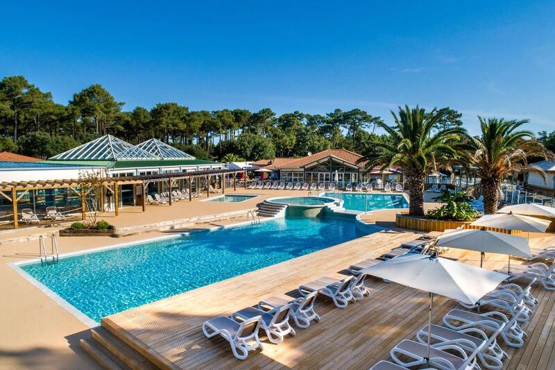 Outdoor pools, jacuzzi and sun loungers at LIBRANOO Naturiste Arnaoutchot campsite, Landes.