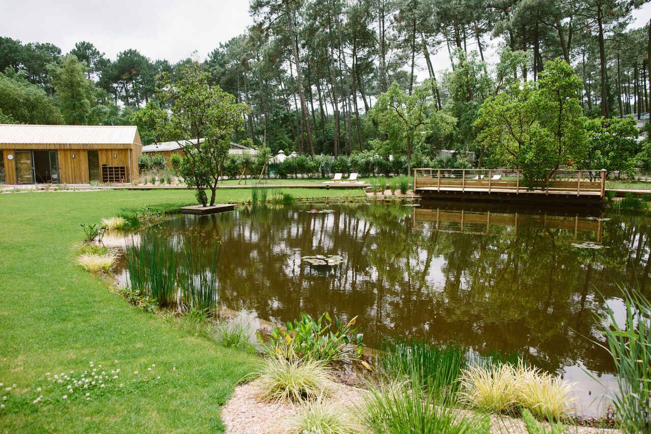 Natural area, wooden deck, modern building at LIBRANOO Naturiste Arnaoutchot campsite, Landes.