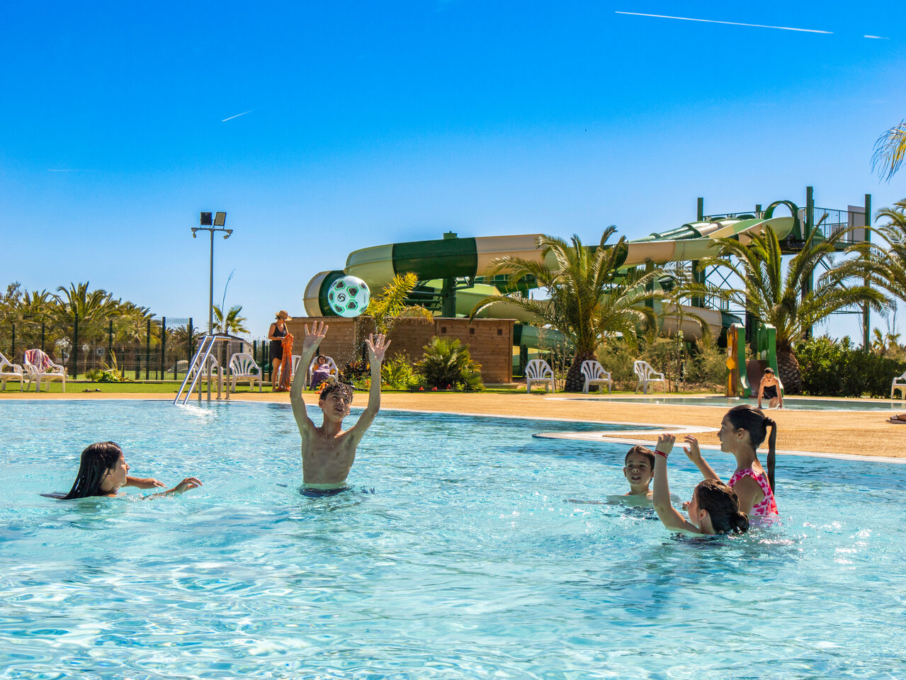 Outdoor pool, slides and children playing at CAPFUN Aube campsite, Tarragona.