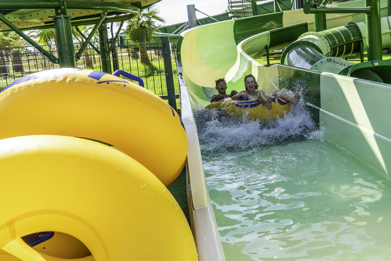 Children on water slide with tube at CAPFUN Aube campsite in Deltebre, Tarragona.