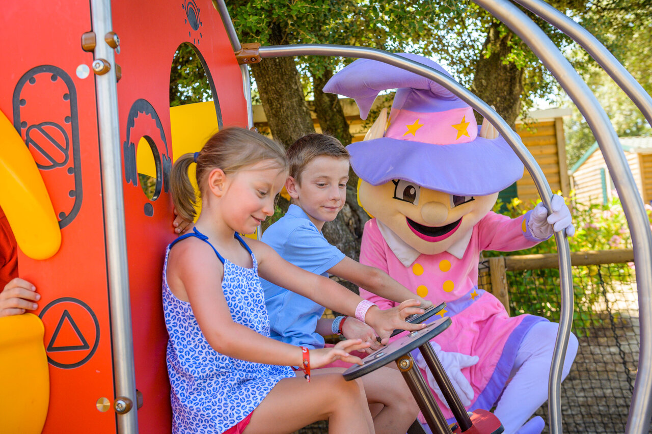 Children playing on playground structure with mascot at CAPFUN Aube campsite in Deltebre, Tarragona.