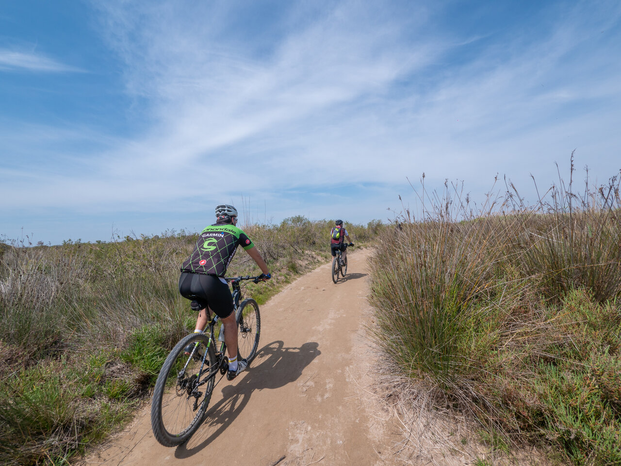 Mountain bikers on natural dirt trail at CAPFUN Aube campsite, Deltebre, Tarragona.