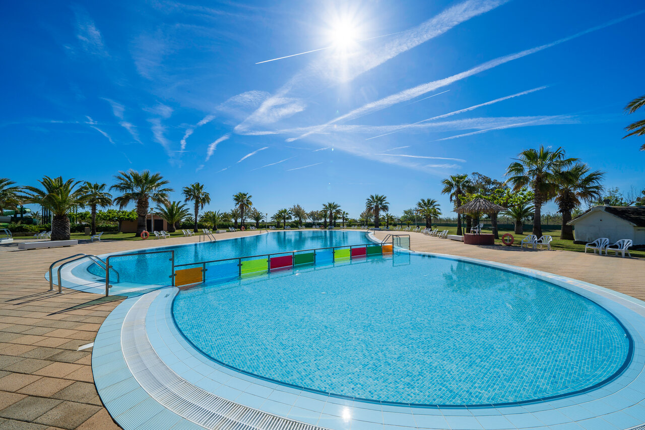 Outdoor swimming pool, separate areas, palm trees, CAPFUN Aube campsite in Deltebre, Tarragona.