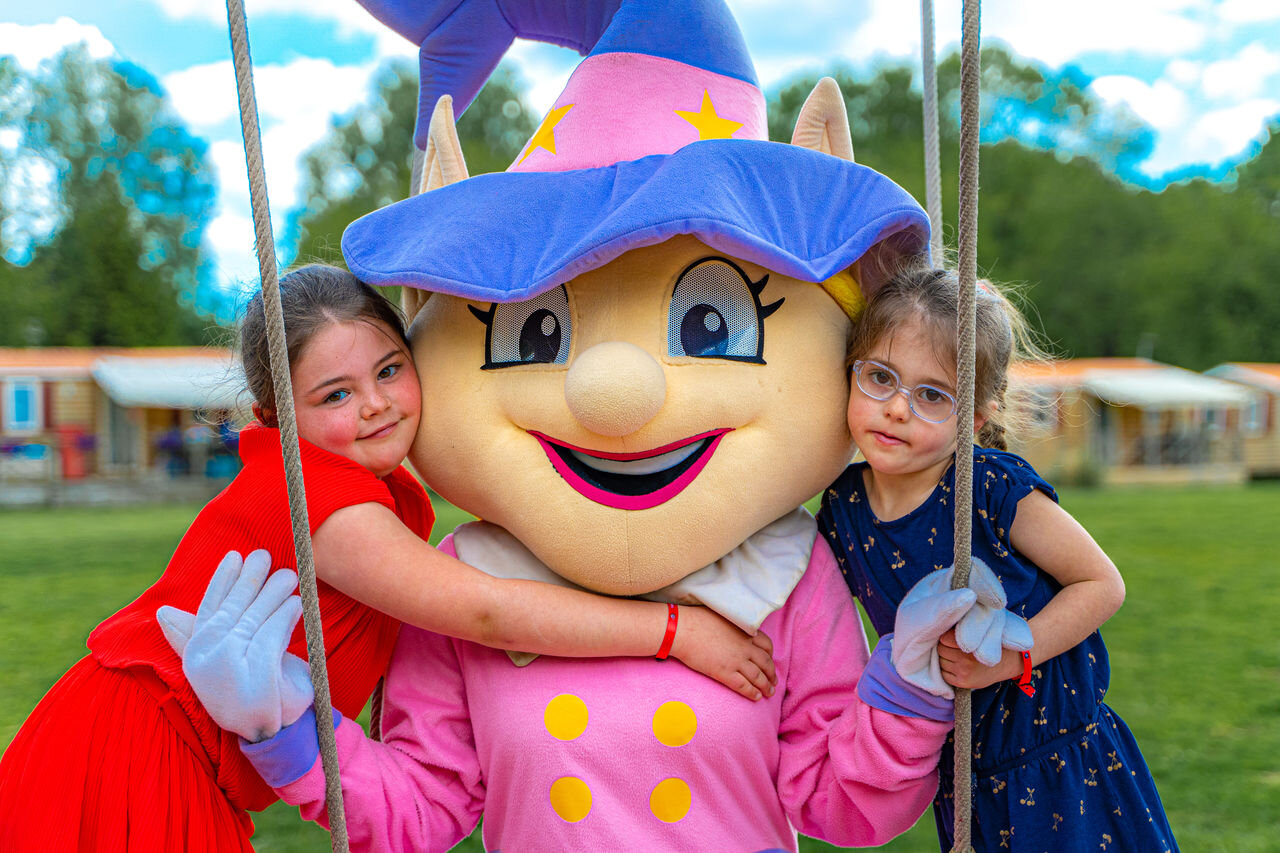 Two girls hugging the mascot at CAPFUN Aube campsite in Deltebre, Tarragona.