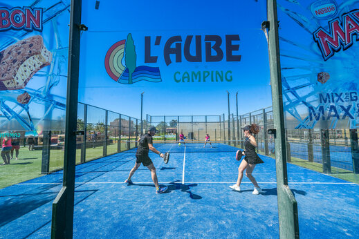 Blue padel court with players at CAPFUN Aube campsite in Deltebre, Tarragona.