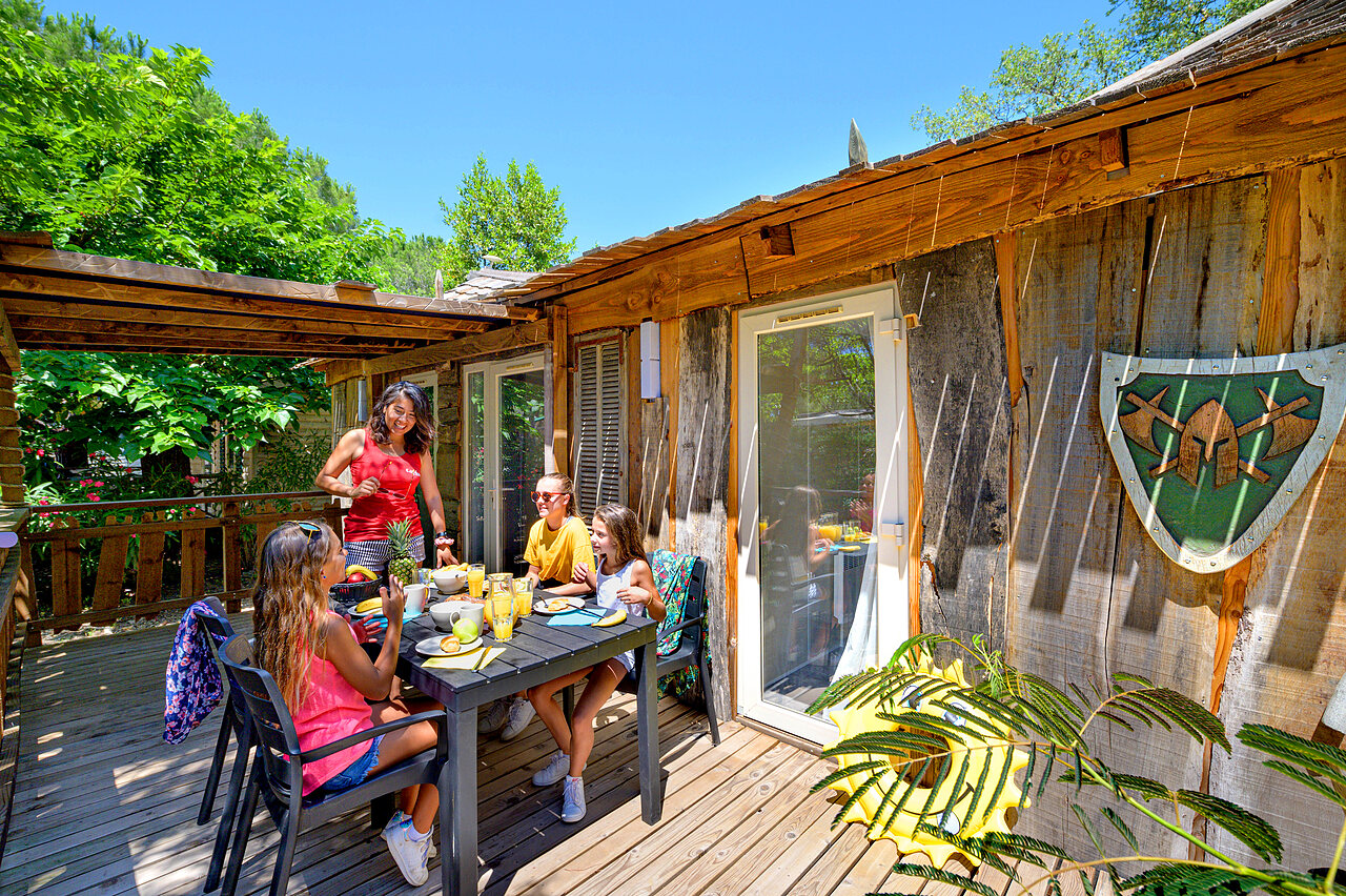 Chalet, family having breakfast on terrace at CAPFUN Aubr�des campsite in Puget sur Argens.