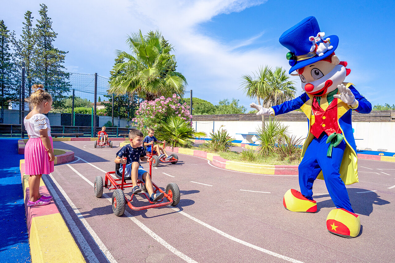 Children on pedal karts with mascot on track at CAPFUN Aubr�des campsite in Puget sur Argens (83).