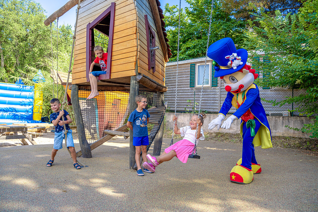 Mascot and children on the playground at CAPFUN Aubr�des campsite in Puget sur Argens (83).