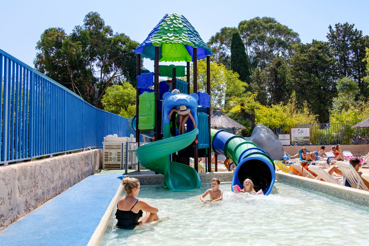 Water play area with slides and children's pool at CLICOCHIC Baie de Cavalaire campsite.