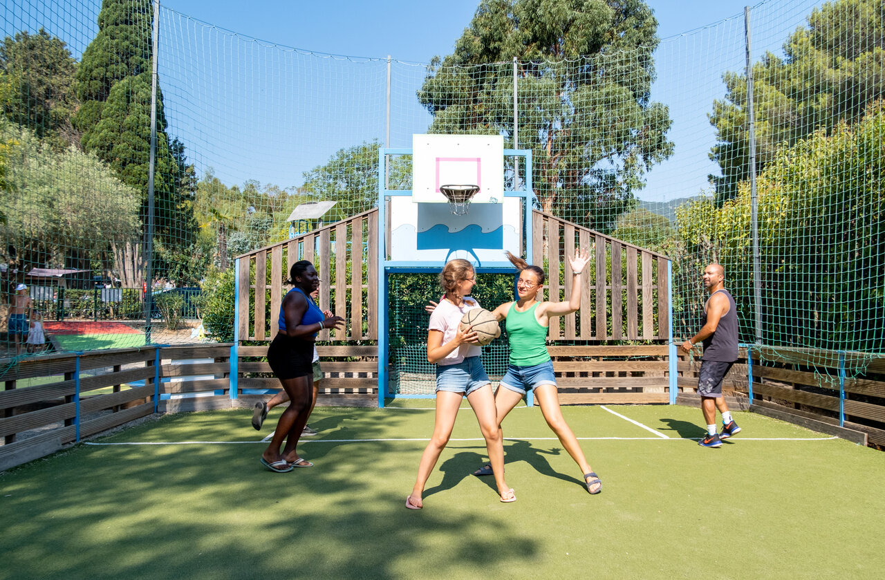 Multisport court with guests playing basketball at camping CLICOCHIC Baie de Cavalaire.