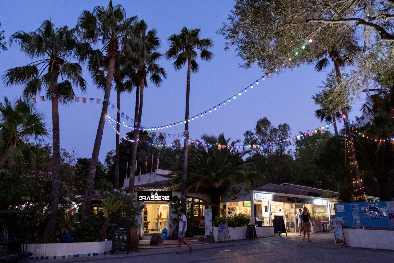 Illuminated restaurant and bar, festive string lights at CLICOCHIC Baie de Cavalaire campsite (83).