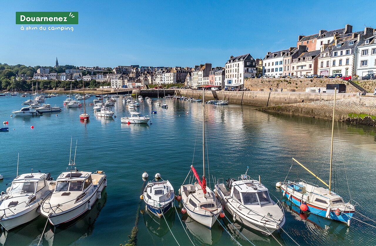 Douarnenez marina in Brittany, with boats and colorful waterfront houses.