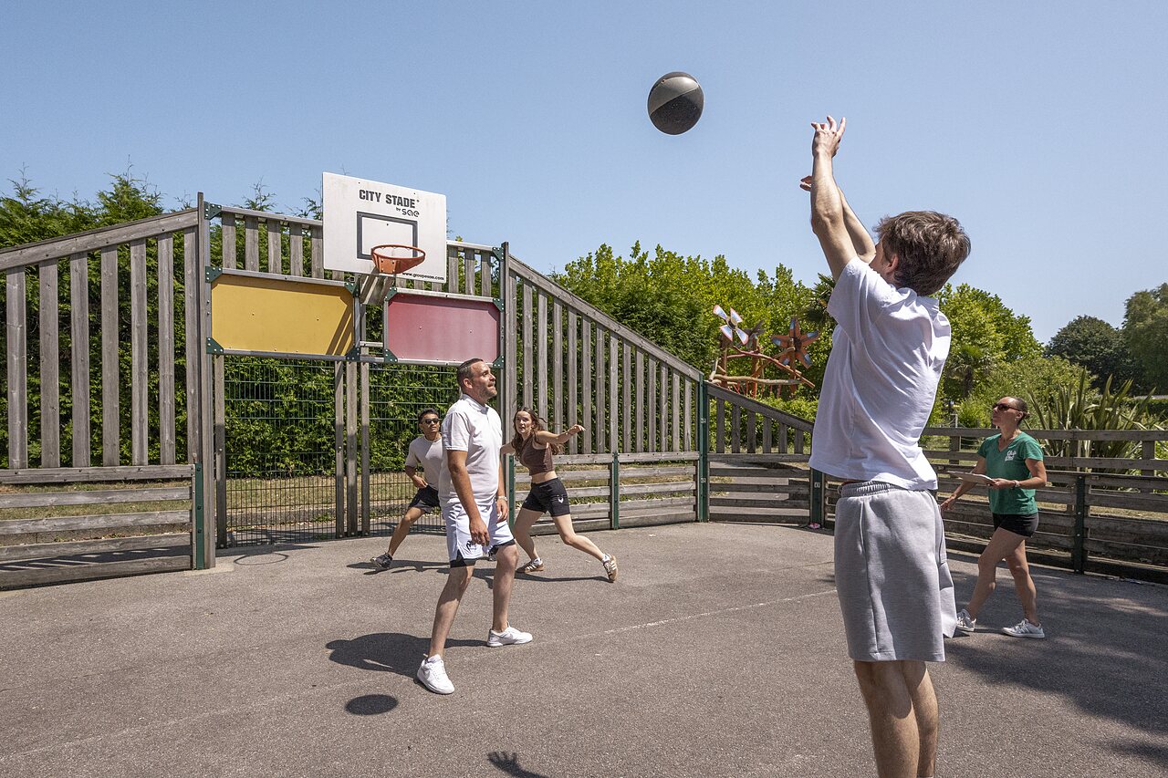 Basketball game on multi-sport court at CLICOCHIC Baie de Douarnenez campsite (29).