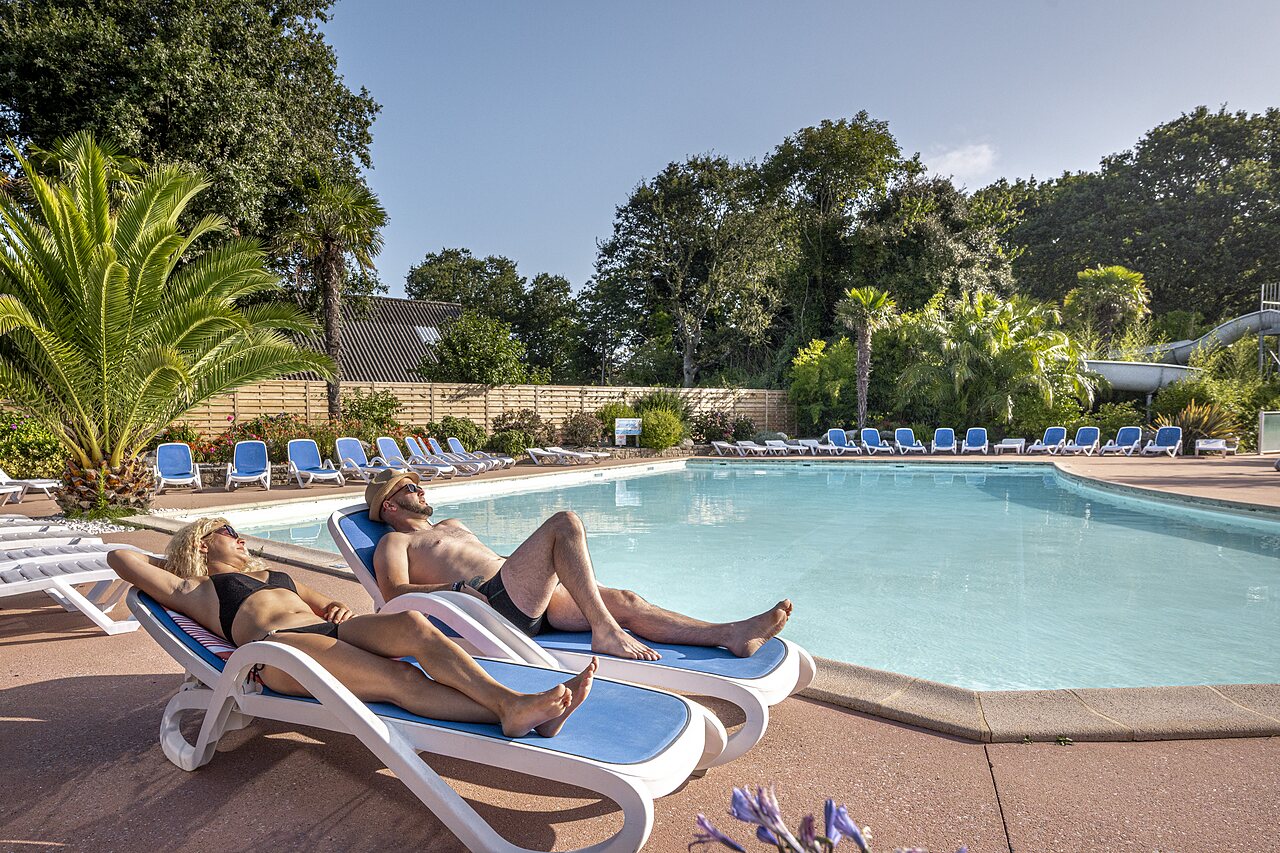 Outdoor swimming pool, waterslide and sun loungers at CLICOCHIC campsite in Poullan-sur-Mer (29).