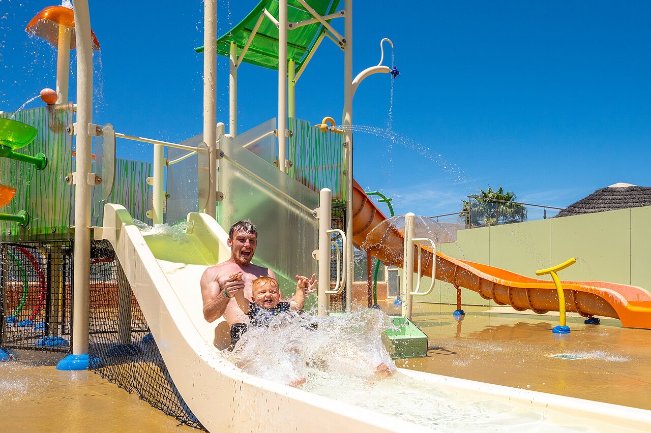 Father and child on water slide, fun at CAPFUN Barbacane campsite in NARBONNE (11).