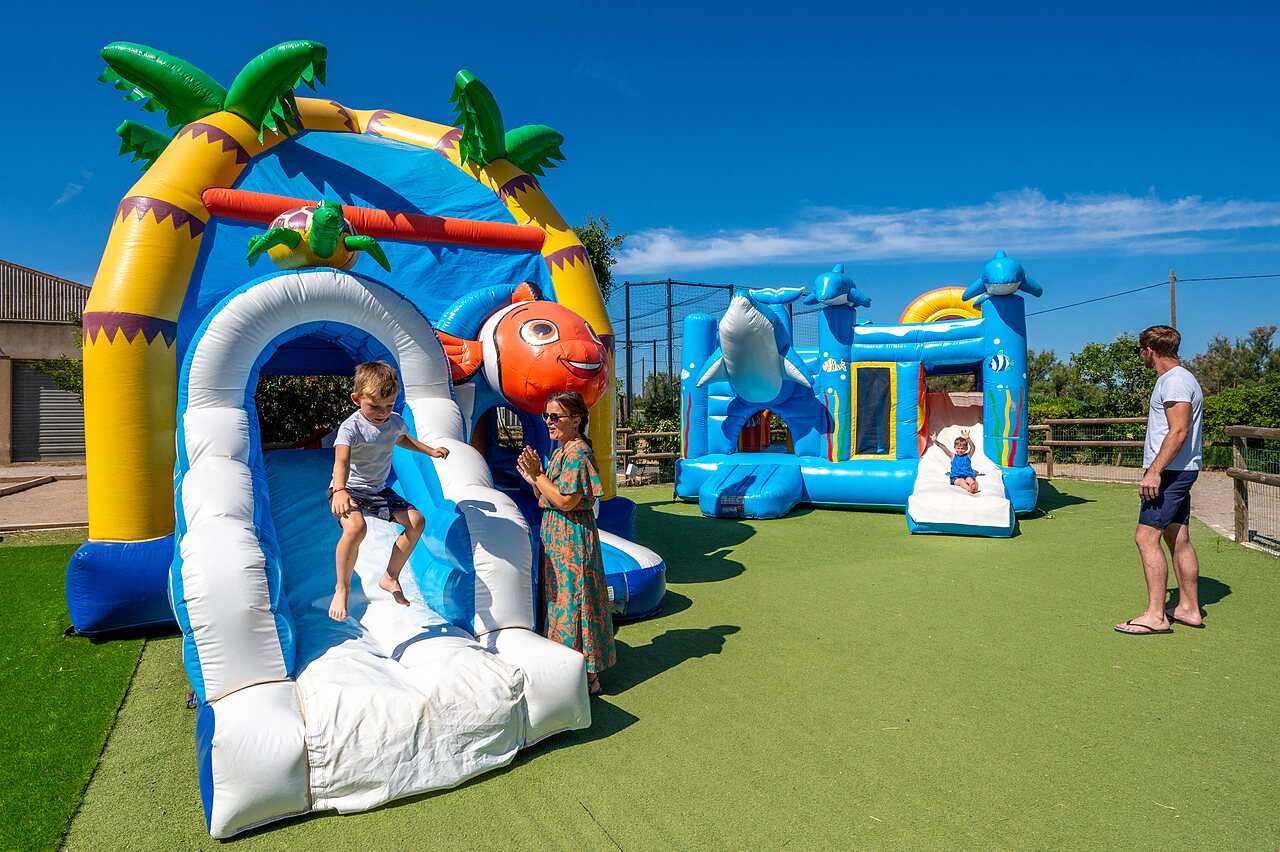 Colorful inflatable games for children with slides at CAPFUN Barbacane campsite in NARBONNE (11).