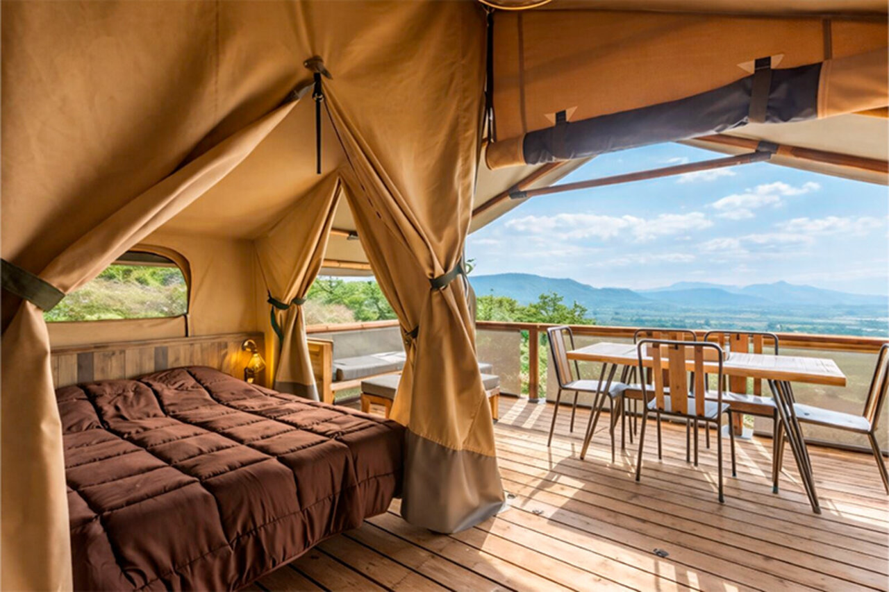 Glamping lodge tent, bed, terrace, panoramic view at CLICOCHIC Bastets campsite.