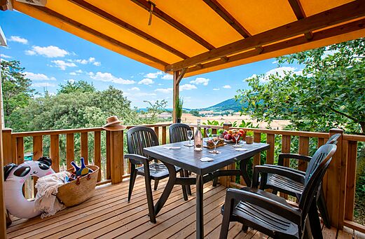 Mobile home terrace with table, chairs at CLICOCHIC Bastets campsite Marsanne.