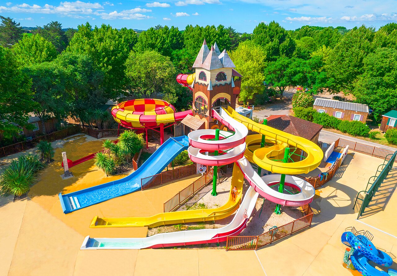 Colorful water slides, play tower, and splash pad at CAPFUN Bastide campsite in N�mes (30).