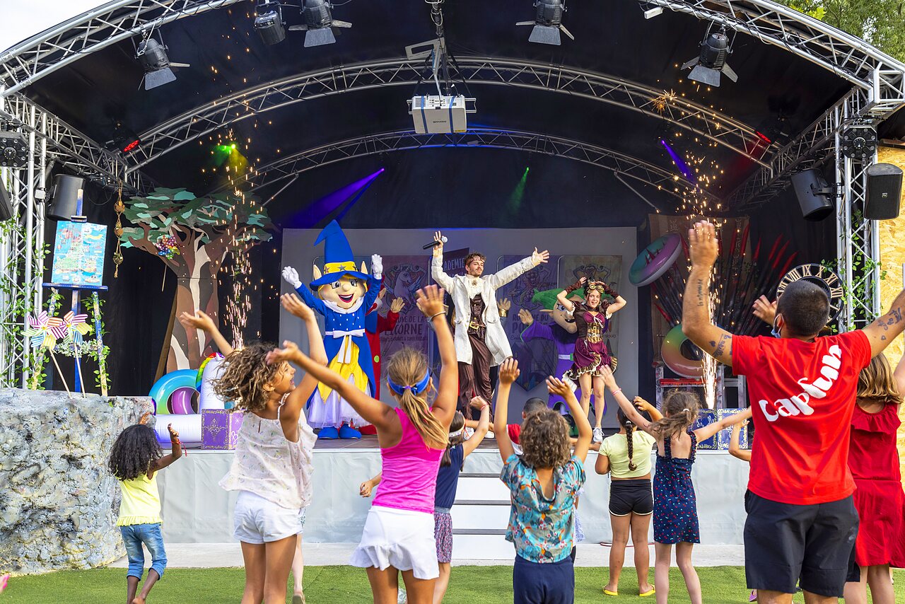 Children dancing in front of animation stage with mascot at CAPFUN Bastide campsite in N�mes (30).