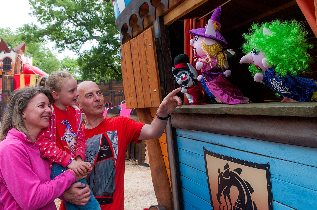 Family watching a puppet show at the outdoor theater, at CAPFUN Bastide campsite in N�mes (30).