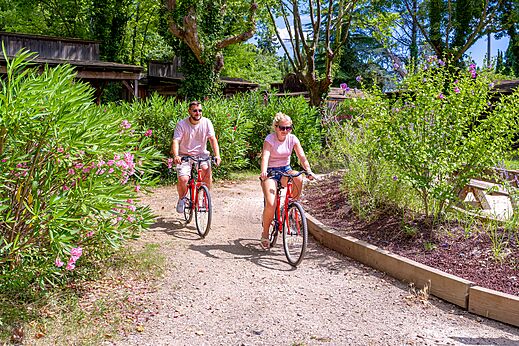 Couple cycling on nature path at CAPFUN Bastide campsite in N�mes (30).