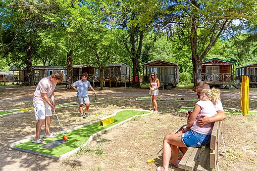 Family playing shaded mini-golf at CAPFUN Bastide campsite in N�mes (30).