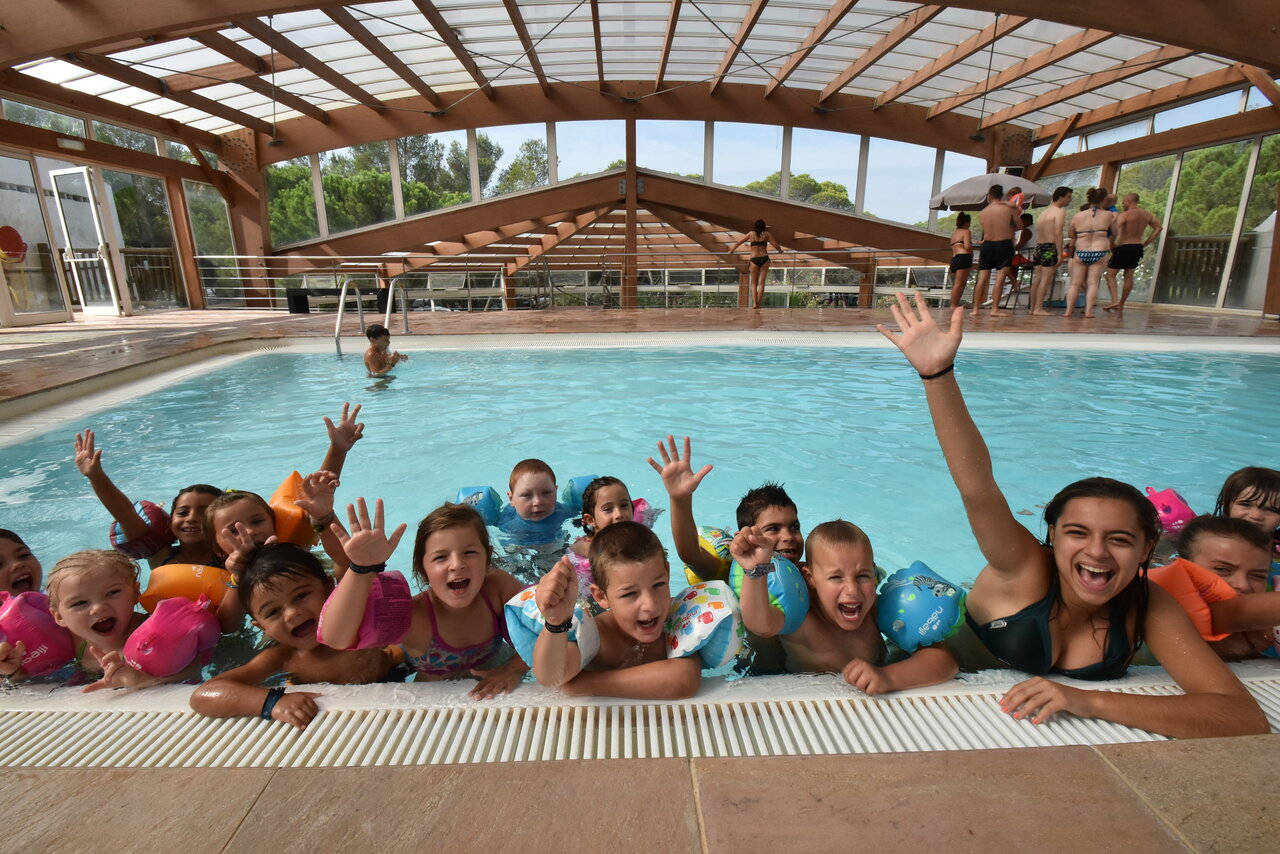 Smiling children and animator in the indoor swimming pool at CAPFUN La Baume - La Palmeraie campsite in Fr�jus (83).