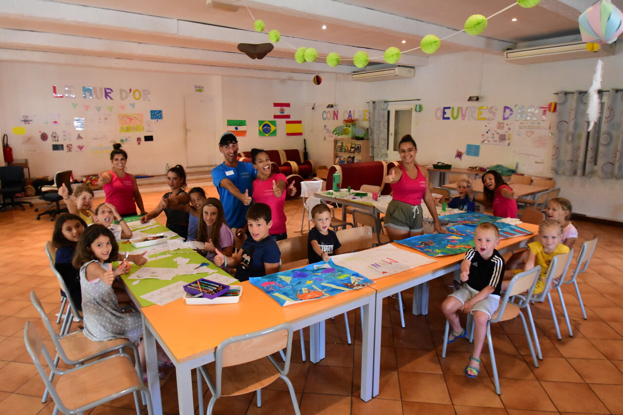 Smiling children and animators during a creative activity at CAPFUN La Baume campsite.