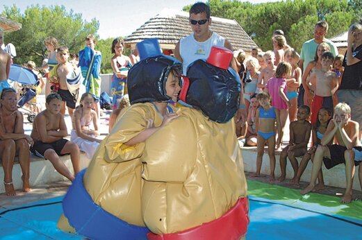 Children in sumo suits enjoying animation at CAPFUN La Baume - La Palmeraie campsite in Fréjus (83).