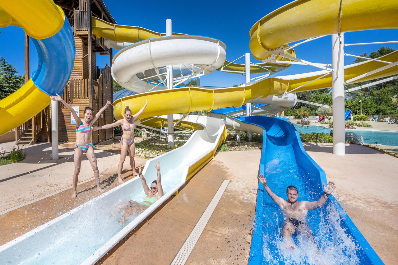 Colorful water slides and people having fun at CAPFUN Beauregard campsite in MORNAS (84).