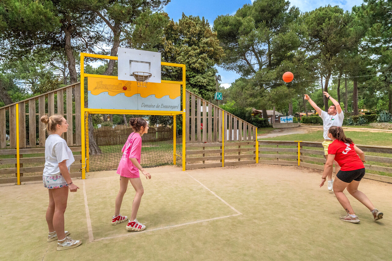 Basketball game on multi-sport court at CAPFUN Beauregard campsite in MORNAS (84).