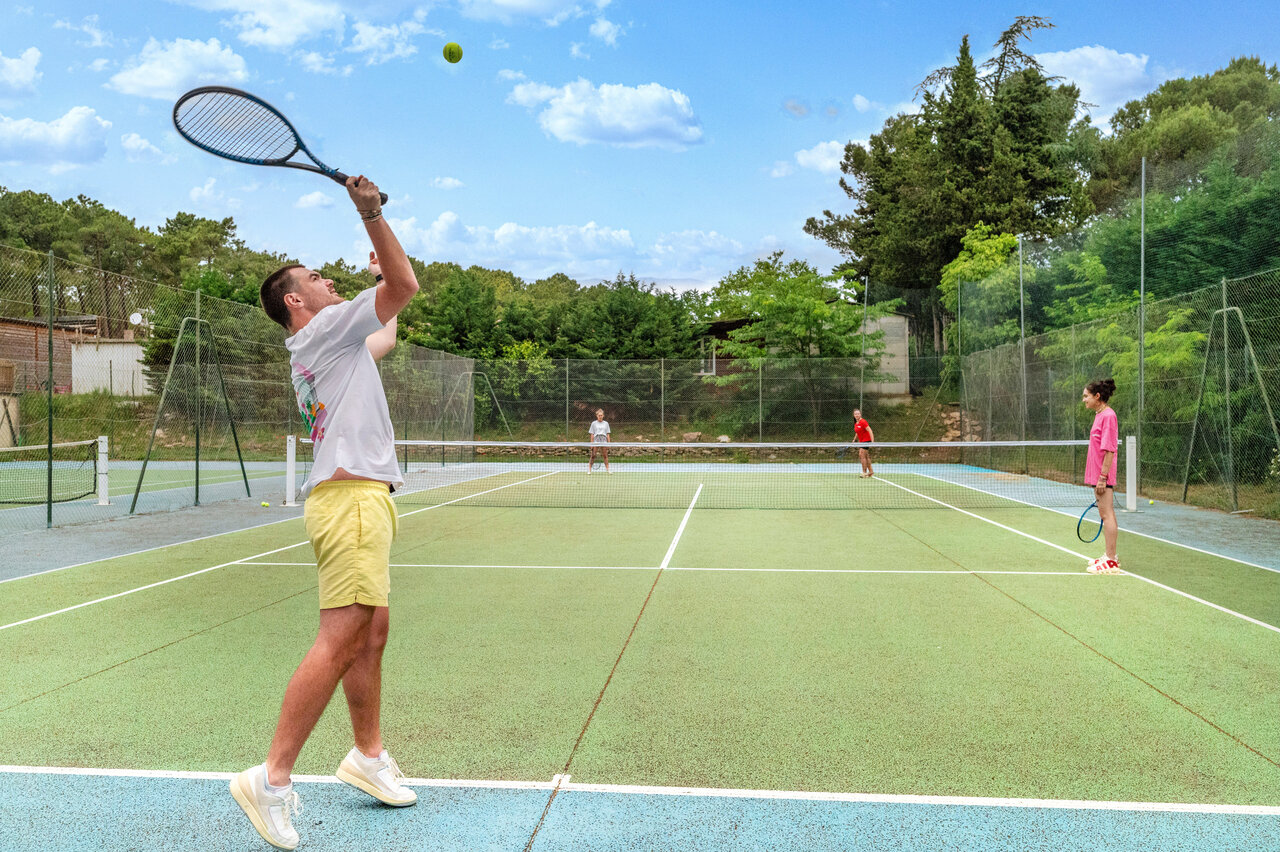 Tennis players on the court at CAPFUN Beauregard campsite in MORNAS (84).