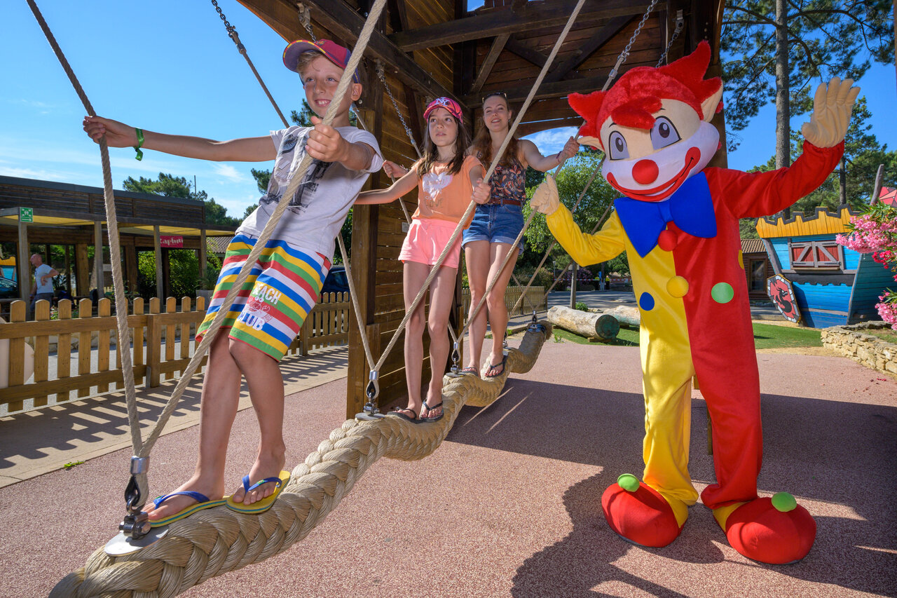 Children playing on rope bridge with mascot at CAPFUN Beauregard campsite in MORNAS (84).